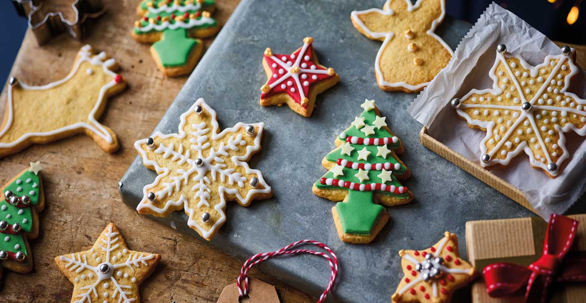 Freshly baked gingerbread cookies on a festive Christmas-themed table, surrounded by holiday decorations