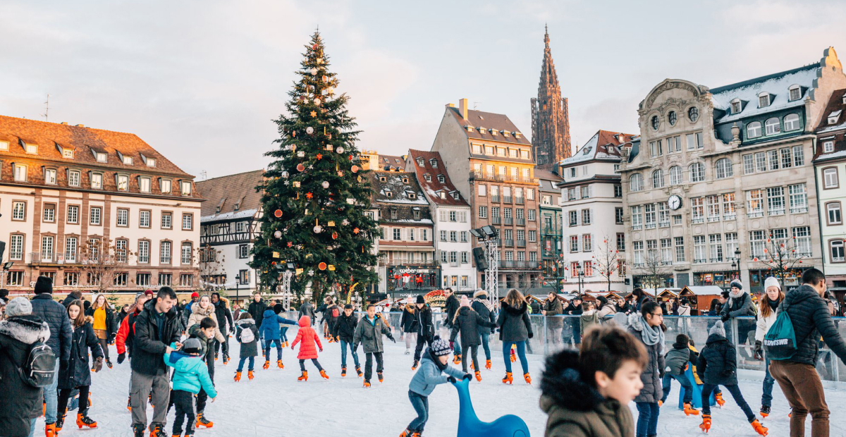 The Strasbourg Christmas Market in France, with festive wooden stalls, sparkling lights, and the historic Strasbourg Cathedral in the background.